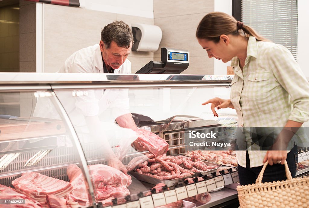 woman buying meat at the butcher shop Butcher's Shop Stock Photo