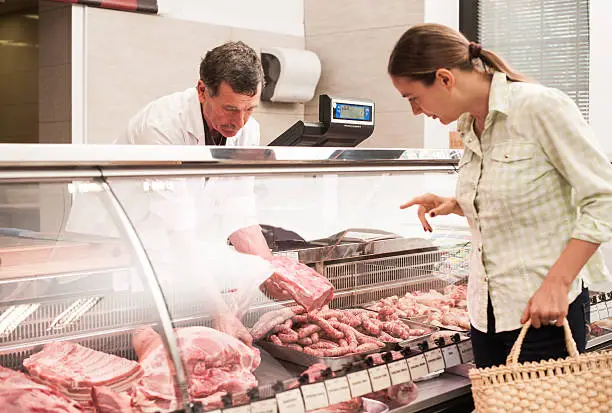 woman buying meat at the butcher shop