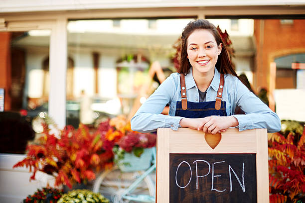 istock Happy florist leaning on sign with open written in chalkboard 544603972