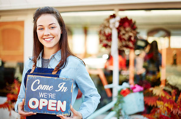 istock Smiling florist holding sign saying come in we're open 544604546