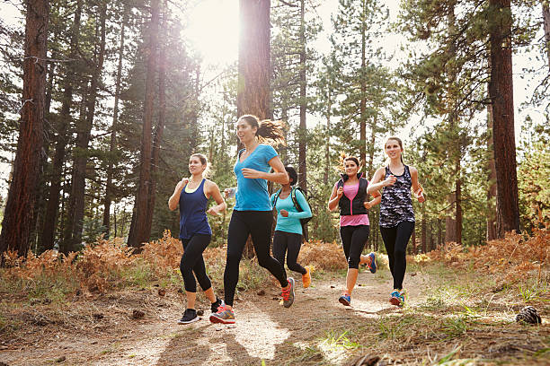 groupe de jeune adulte femme courir dans la forêt, à proximité - cross country running running jogging black and white photos et images de collection