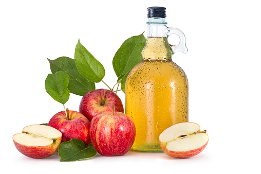 Cider and red apples with green leaves on white background