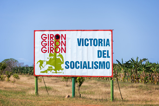 Playa Giron, Cuba - April 27, 2016: Sign with text meaning 'Victory of socialism' on the road to Playa Giron, best known as the famous Bay of pigs in Cuba
