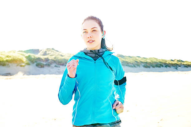 istock Sporty woman jogging on beach during summer 544656802