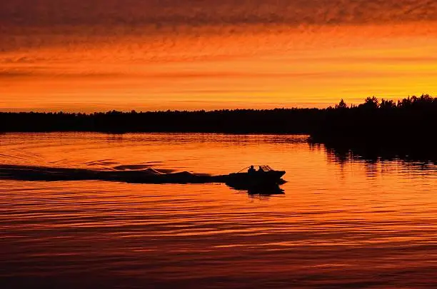 Boat Motoring After Sunset on a Calm Lake