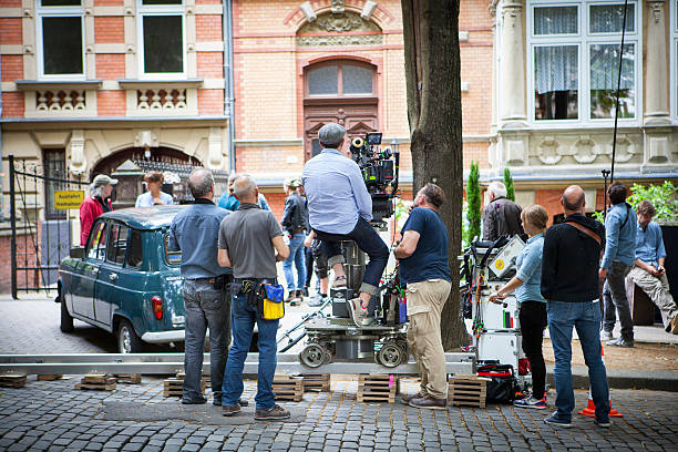 Movie set on a street in Wiesbaden Wiesbaden, Germany - July 5, 2016: A film crew at a movie set in front of a residential building in the city center of Wiesbaden, Germany. Wiesbaden is the capital of the German federal state Hessen and because of its old historism architecture very popular with movie producers. film studio stock pictures, royalty-free photos & images