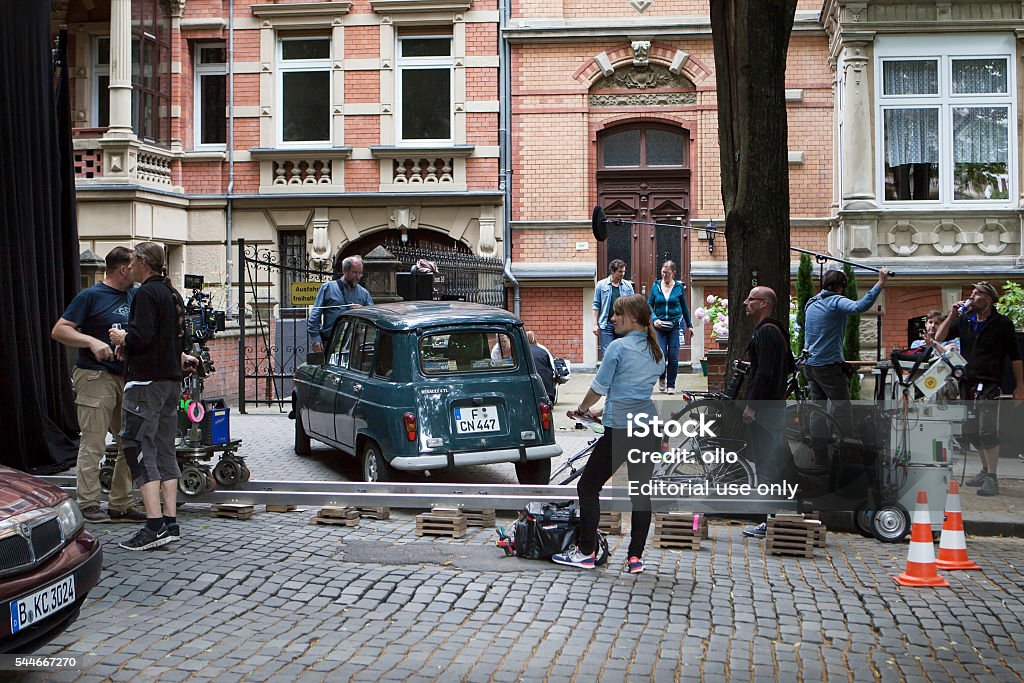 Movie set on a street in Wiesbaden Wiesbaden, Germany - July 5, 2016: A film crew at a movie set in front of a residential building in the city center of Wiesbaden, Germany. In the foreground a bystander. Wiesbaden is the capital of the German federal state Hessen and because of its old historism architecture very popular with movie producers. Film Set Stock Photo