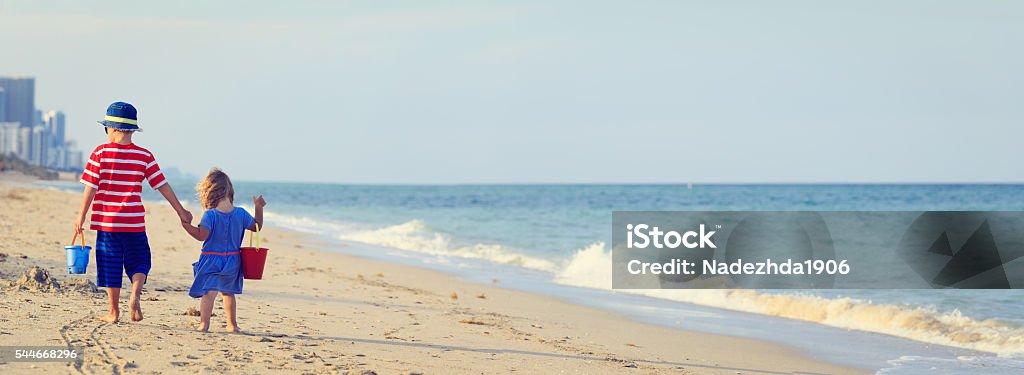 little boy and girl walking on beach little boy and girl walking on beach, panorama Family Stock Photo