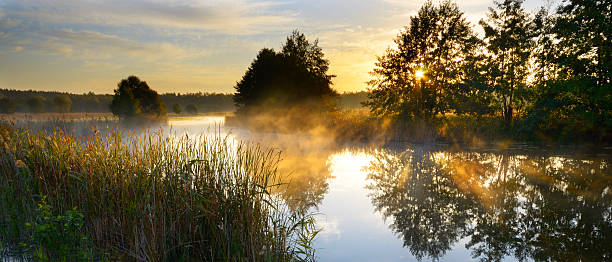 川に沈む夕日  - sun fog sky river ストックフォトと画像