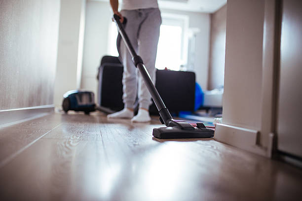 istock Woman using vacuum cleaner at home 544670714