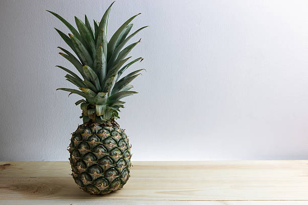 istock Green pineapple place on the wood floor 544671124