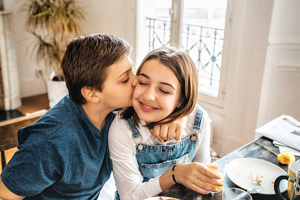 istock french boy embracing sister at breakfast table 544671280
