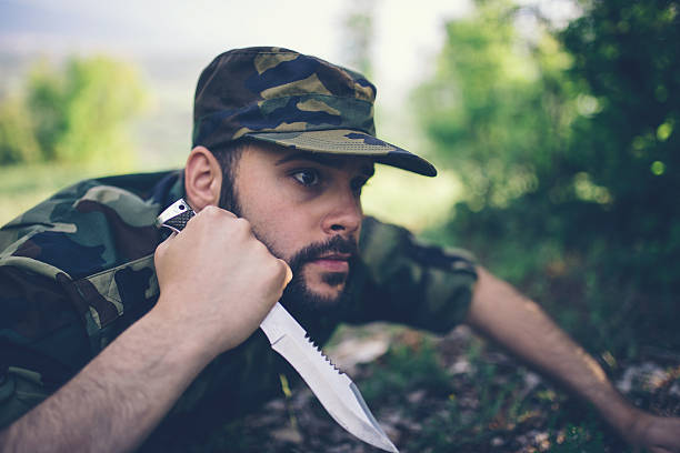 istock Young soldier with knife in forest 544672560