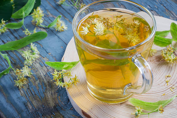 istock Cup with linden tea and flowers on wooden table. 544674498
