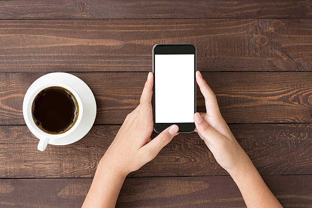 istock phone white screen in woman hand on table top view 544674532