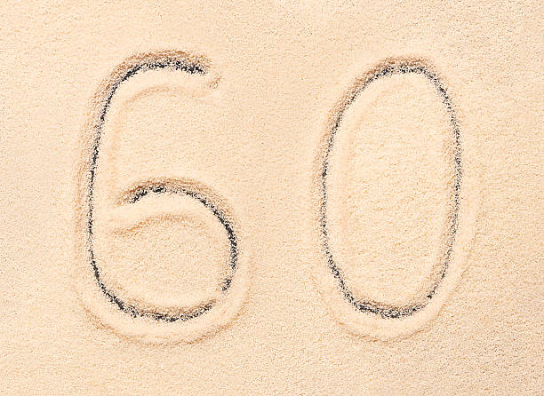 istock 60 number written on beach sand. Summer background 544677842