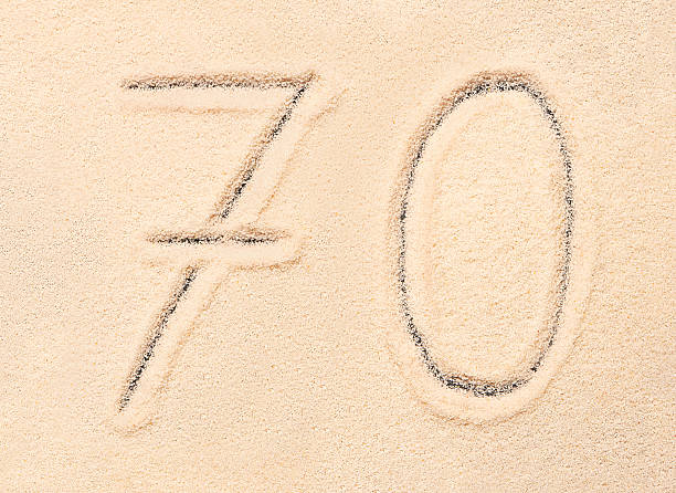 istock 70 number written on beach sand. Summer background 544677962