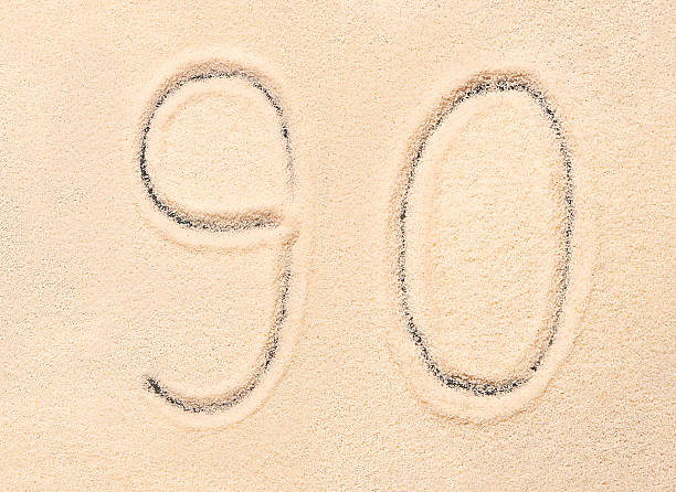 istock 90 number written on beach sand. Summer background 544678238