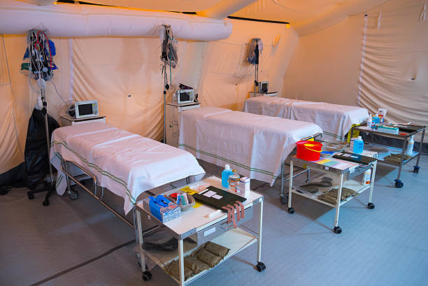 Inside field hospital tent A field hospital is a small mobile medical unit, or mini hospital, that temporarily takes care of casualties on-site before they can be safely transported to more permanent hospital facilities. emergency shelter stock pictures, royalty-free photos & images
