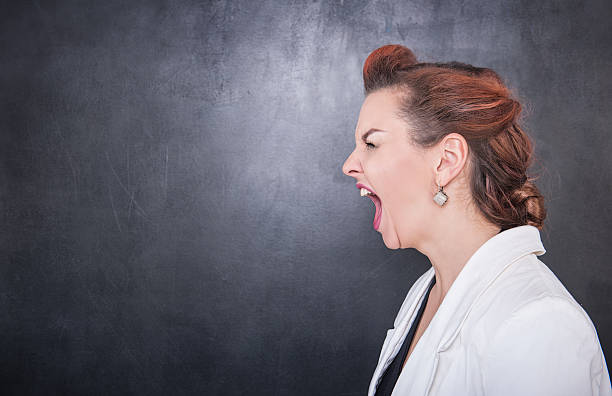 istock Angry screaming teacher on blackboard background 544680646