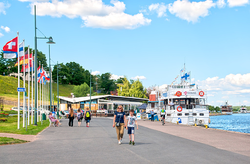 Lappeenranta, Finland - June 15, 2016: People walk near boats on the bank of Saimaa Lake in summer