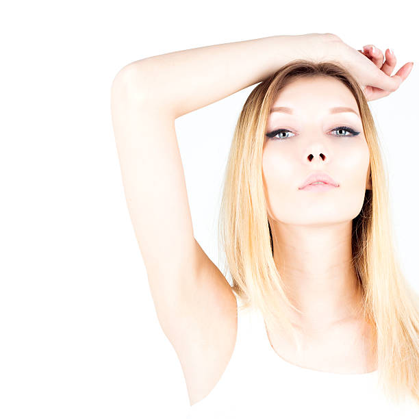 Beautiful woman on a white background with her hand raised. Waxing armpit. Epilation result. Smooth and fresh skin