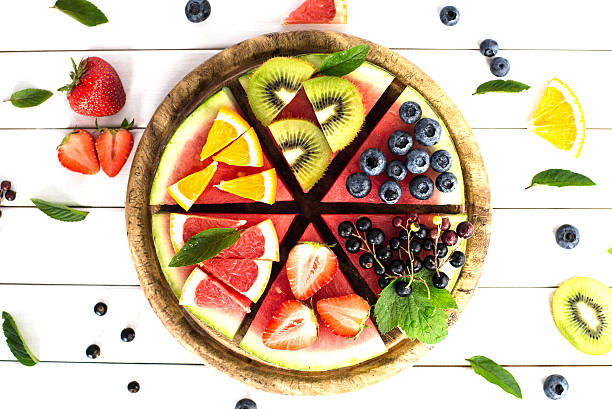 istock Sliced juicy watermelon pizza on white wooden table. Concept 544684062