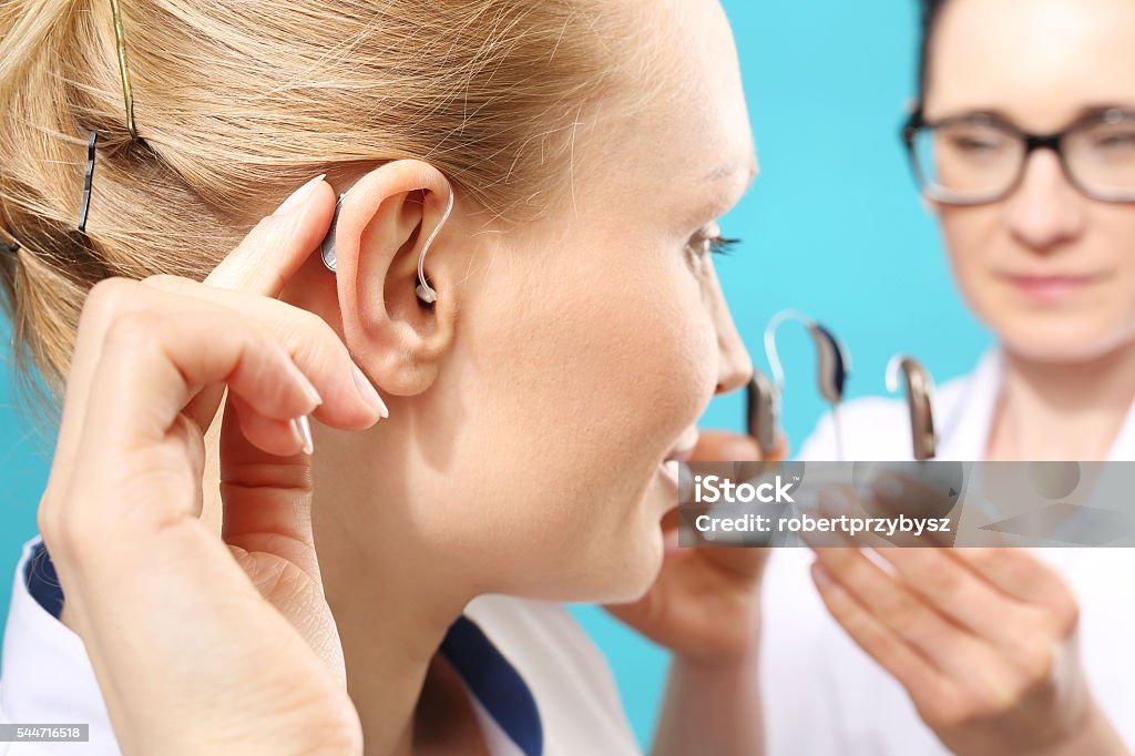 Young woman assumes a hearing aid Hearing Aid Stock Photo