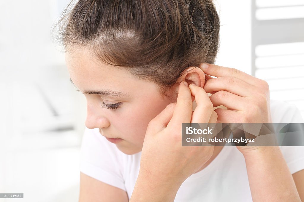 Child with a hearing aid. The girl assumes hearing aid Hearing Aid Stock Photo