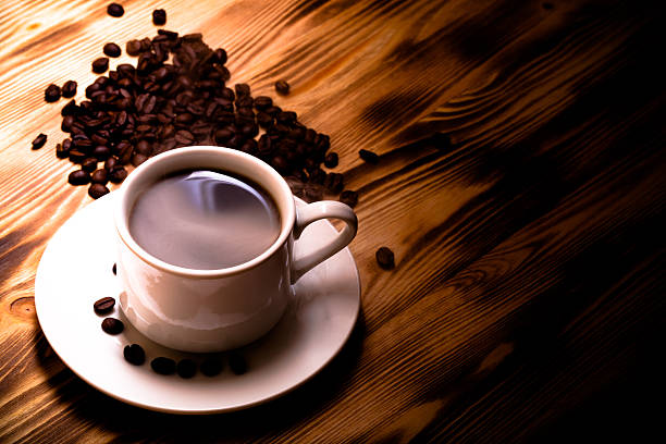 istock Coffee beans and coffee in white cup on wooden table 544720256