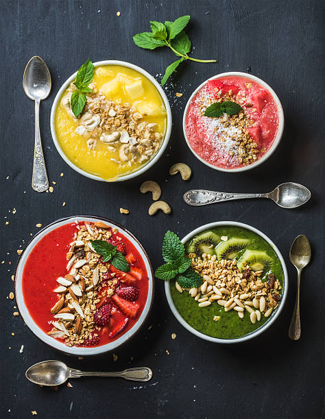 istock Healthy summer breakfast concept. Colorful fruit smoothie bowls with nuts 544721914
