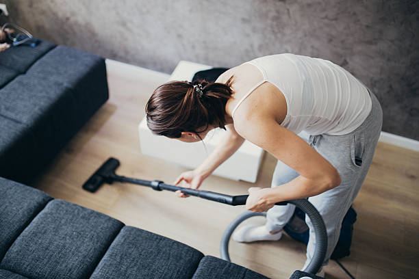 Girl doing house work Woman cleaning the floor in living room with vacuum cleaner. sweeping photos stock pictures, royalty-free photos & images