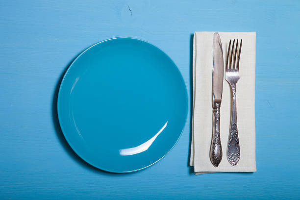 istock Plate, fork and knife in napkin on wooden background 544724350