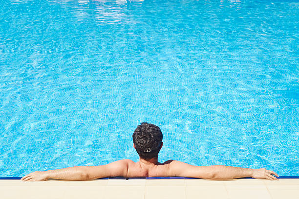 istock Man Relaxing at a Resort Swimming Pool 544724726