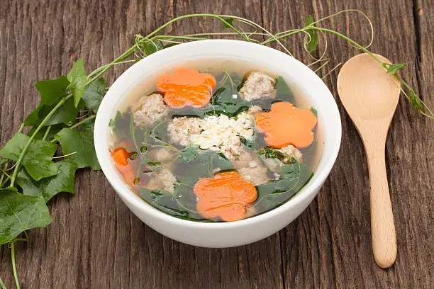 soup with pork and gourd on wooden background and wooden spoon