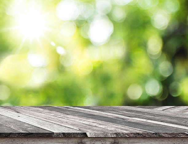 istock Empty grunge wood table top with green blur nature 544735260