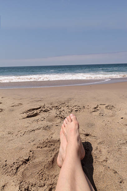 istock Feet and legs crossed and relaxed on a beach 544736510