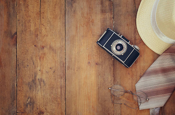istock Vintage camera, glasses and fedora hat on wooden table 544739300