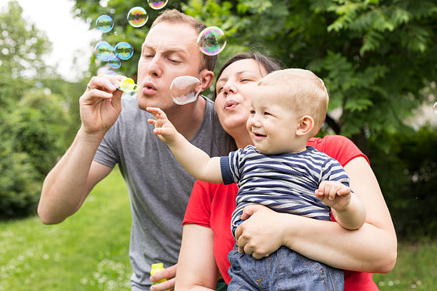 happy family blowing bubbles stock photo