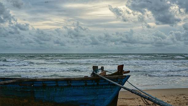 istock Old wooden boat lying on beach, tied down with rope 544741292