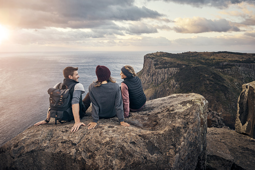 Full length shot of a group of friends admiring the view of the ocean while hiking