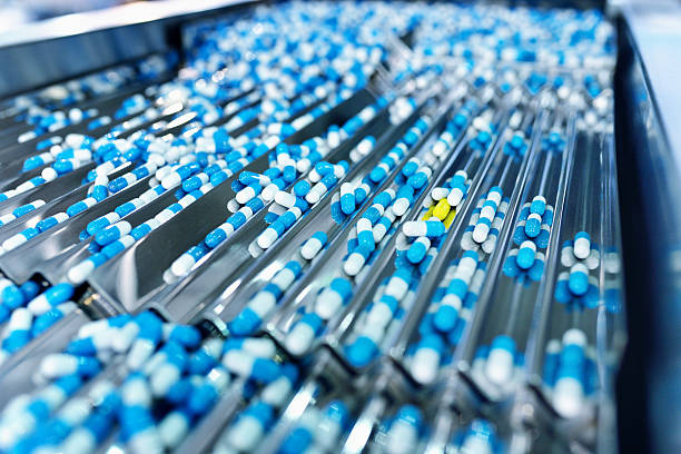 capsule production line - farmaceutische fabriek stockfoto's en -beelden