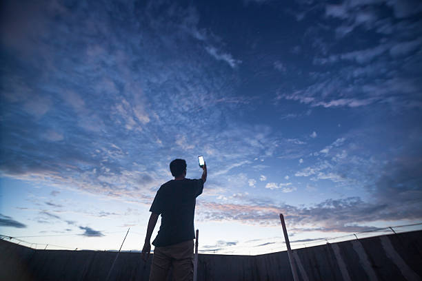 man with phone up to the universe