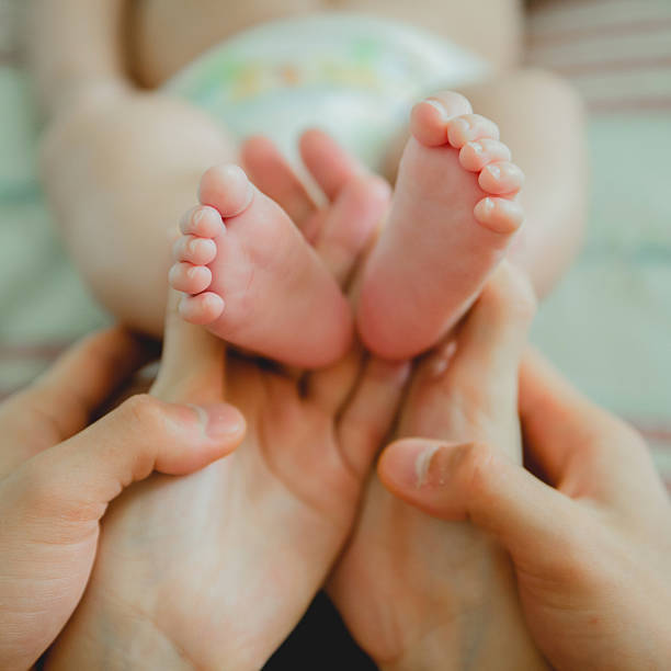 istock Baby feet in mommy's hands 544747322