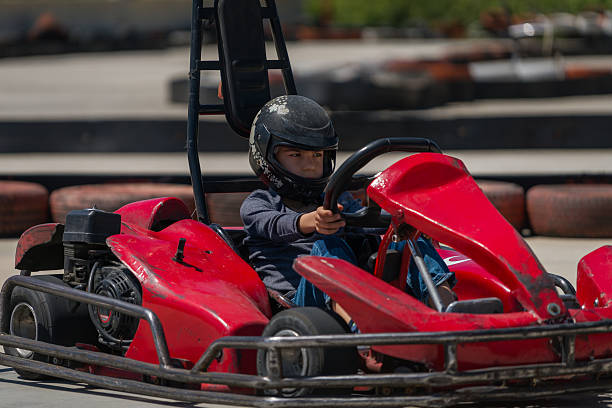 garoto dirigindo um kart em uma pista de corrida - go cart - fotografias e filmes do acervo