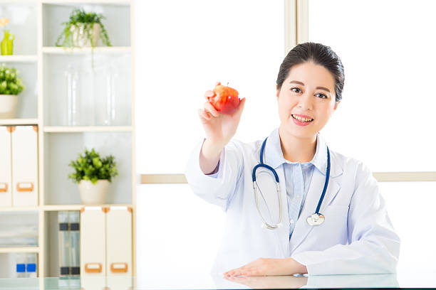 istock Young asian nutritionist holding an apple 544748930