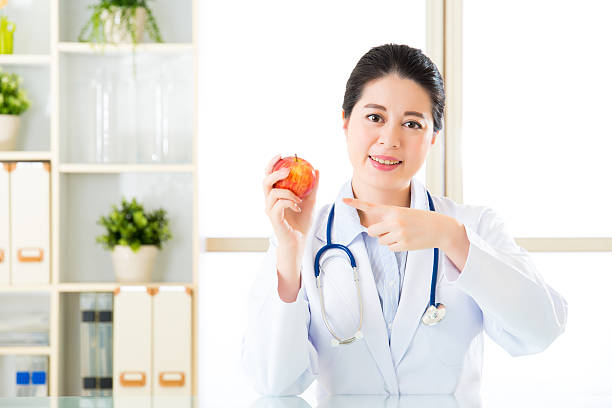 istock Young asian nutritionist recommend eating apple 544749096