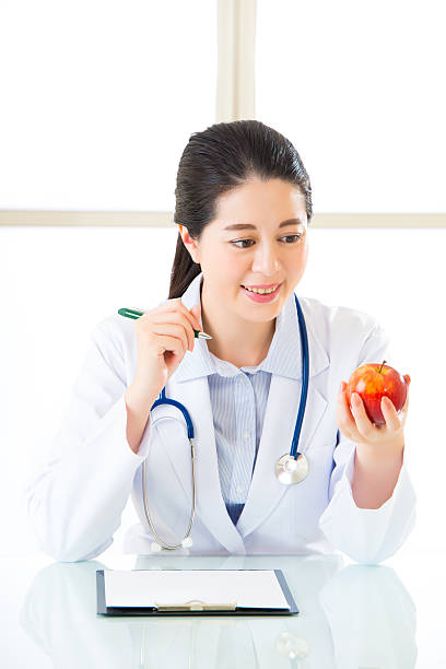 istock Young asian nutritionist doctor writing diet plan 544749448