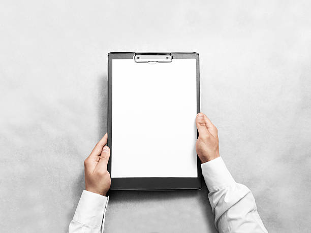 Hand holding blank clip board with white paper design mockup.