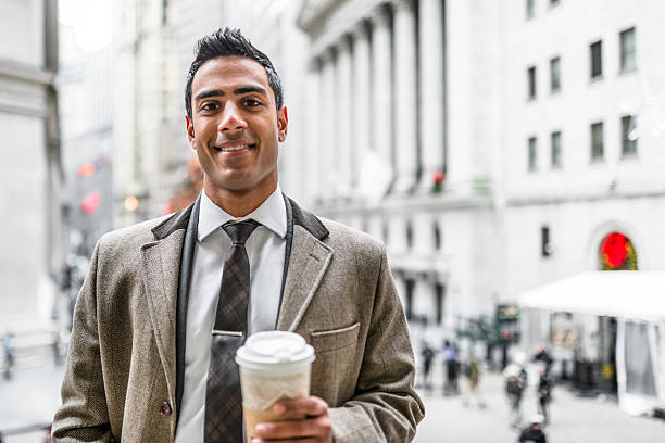 Businessman with coffee mug on wall street